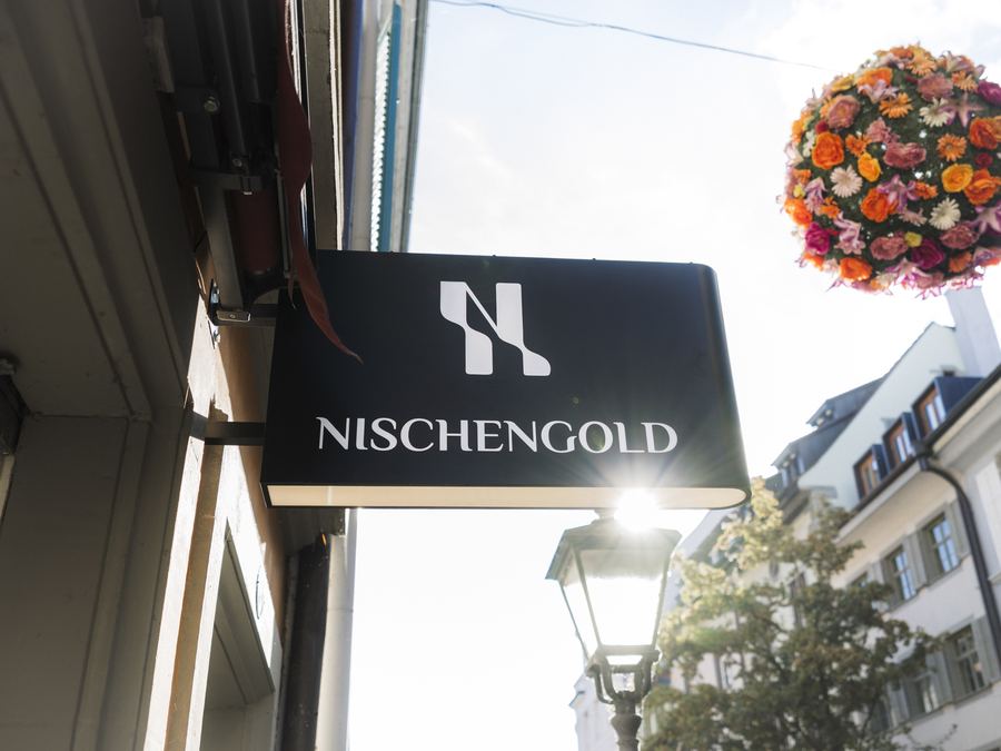 Beleuchteter Ausleger von Nischengold mit Straßenlaterne und hängendem Blumenschmuck, Konstanzer Altstadt