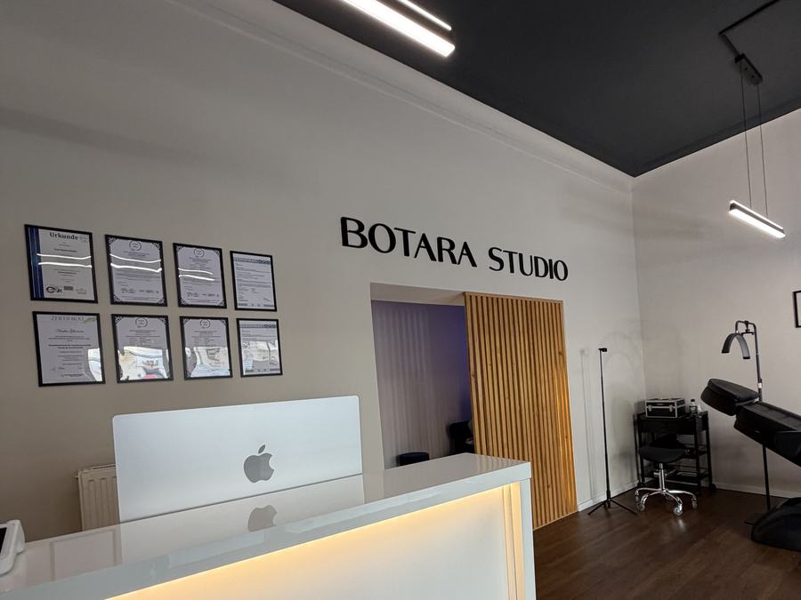 Innenbereich von BOTARA Studio mit Empfangstheke, Zertifikaten und Blick in den Behandlungsraum