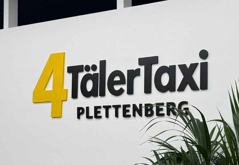 Lackiertes 3D-Wandlogo mit 12 mm Tiefe, direkt auf die Wand geklebt — Projekt 4 Täler Taxi Plettenberg, reale Umsetzung von Visuellewand