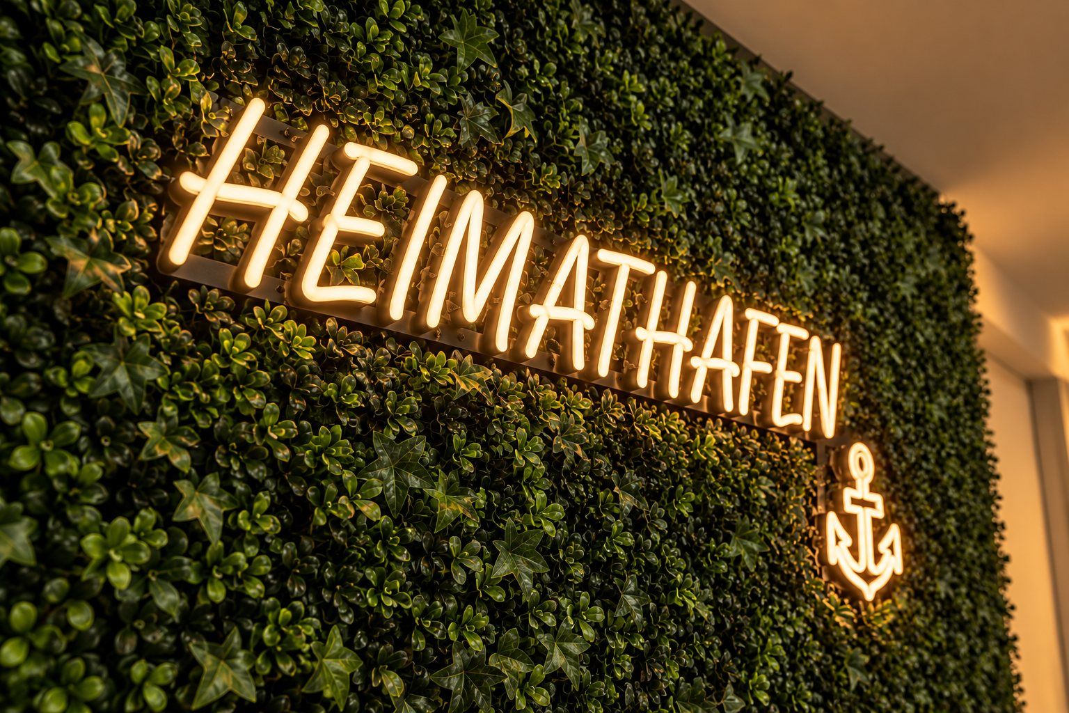 LED-Schild „Heimathafen“ auf Kunstpflanzenwand für die Ärzteversorgung Westfalen-Lippe – Referenzprojekt von Visuellewand