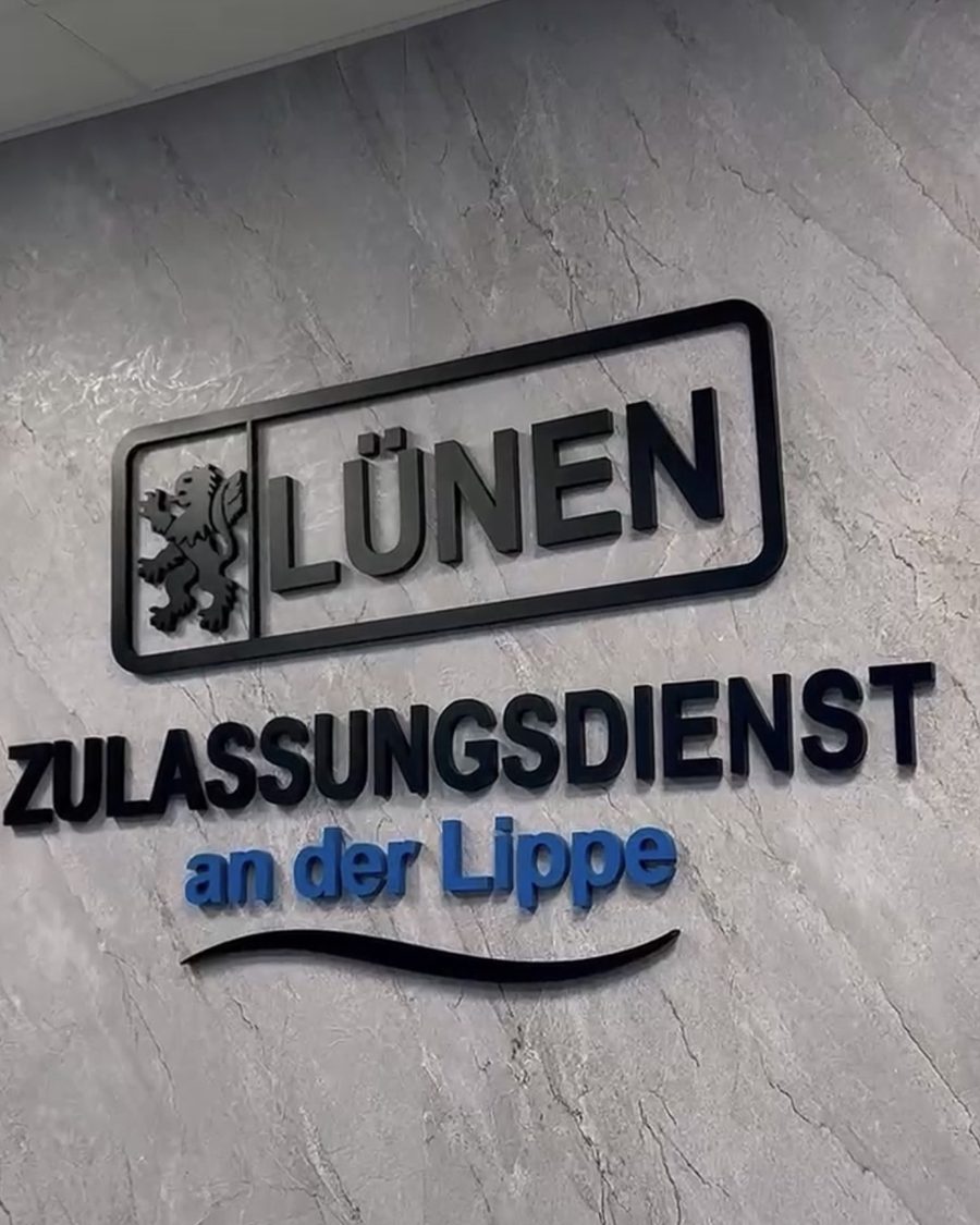 Nahaufnahme des 3D-Wandlogos „LÜNEN ZULASSUNGSDIENST an der Lippe" auf der Marmorpaneelwand