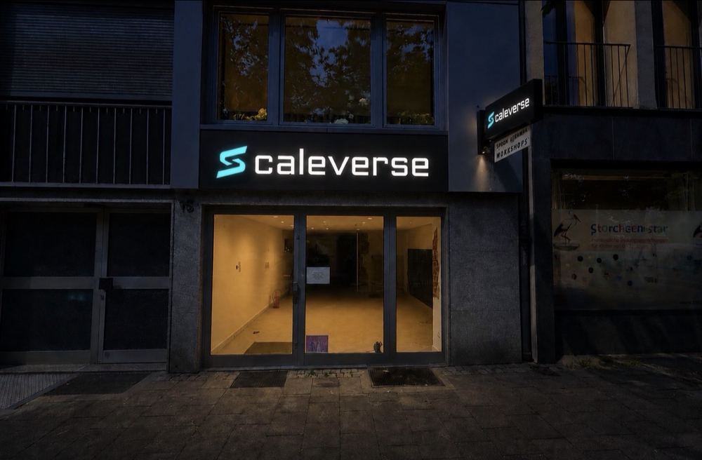 Scaleverse Düsseldorf: Fassade nach Montage von Leuchtkasten und Auslegerschild, beleuchtet bei Dämmerung